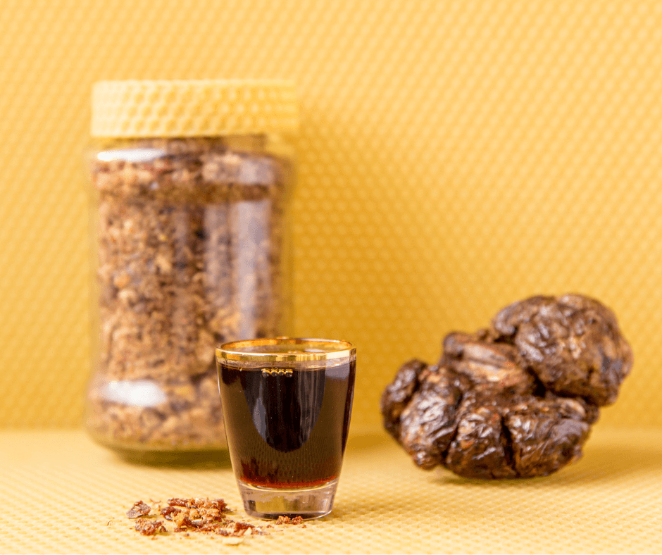 un pot transparent contient de la propolis brute, probablement sous forme de morceaux ou de granulés. Le contenu semble naturel et non transformé, soulignant une origine authentique.