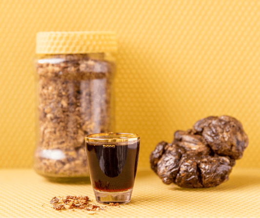 un pot transparent contient de la propolis brute, probablement sous forme de morceaux ou de granulés. Le contenu semble naturel et non transformé, soulignant une origine authentique.